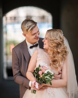 Gelin ve damat şehrin kemerinin altında duruyor..