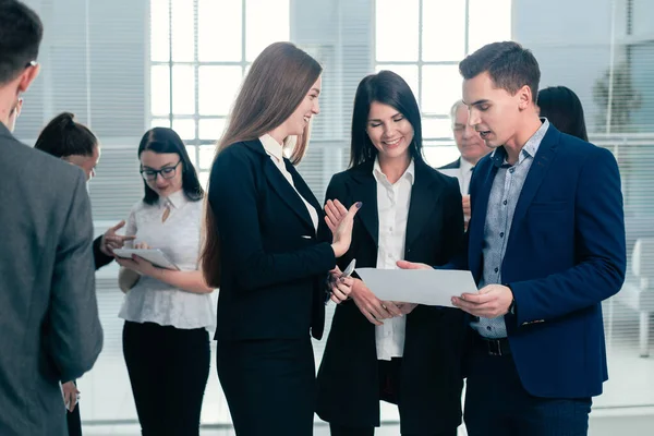 Grupo de jóvenes empleados discuten un documento de negocios . — Foto de Stock