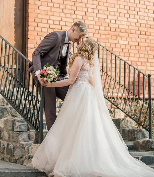 Bride and groom kiss, standing on the porch of the house — Stock Photo, Image