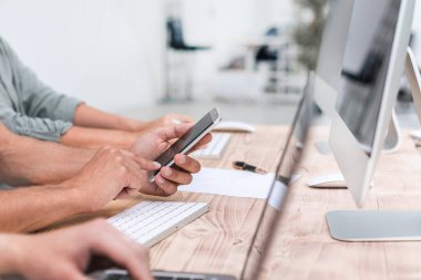 yakın kapatın. genç çalışanlar onun akıllı telefon ekranına bakıyor.