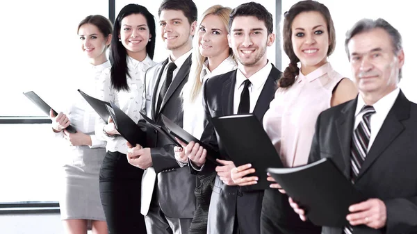 Equipo de negocios que sostiene el portapapeles de pie en la oficina — Foto de Stock