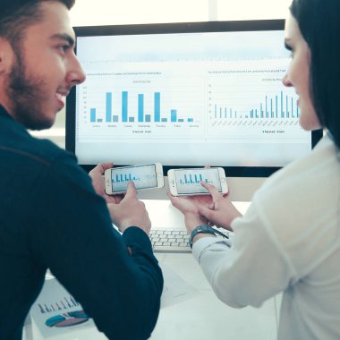 Arka manzara. İş çifti mali tabloları tartışıyor, oturuyor.