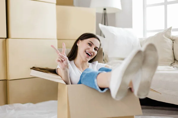 Счастливая молодая женщина, сидящая в большой картонной коробке — стоковое фото