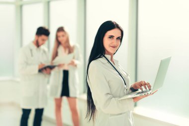 Gülümseyen doktor terapist dizüstü bilgisayar kullanıyor.