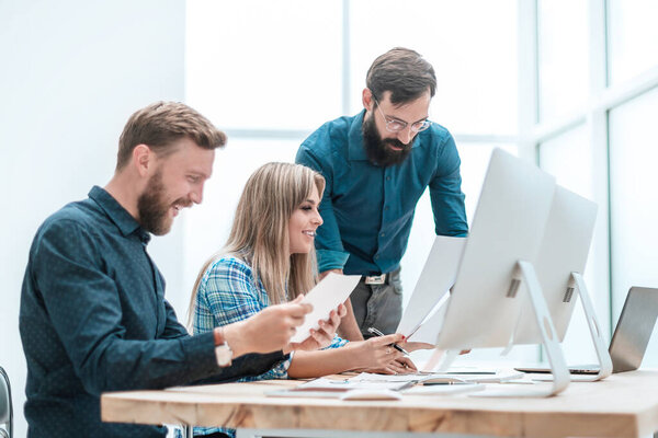 улыбающиеся сотрудники проверяют финансовые отчеты. бизнес концепция
