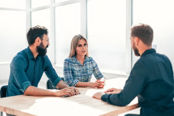 Gestores e candidatos a emprego sentados à mesa durante a entrevista — Fotografia de Stock