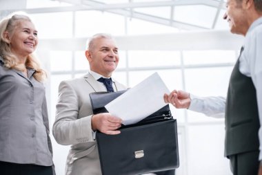 Kapat. Banka çalışanından belge alan işadamı.