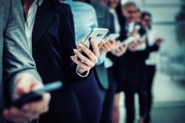 group of diverse employees with smartphones standing in a row