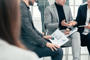 İş arkadaşları konferans odasında mali verileri tartışıyor