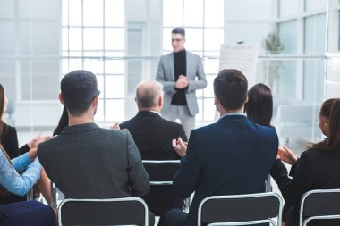 İzleyiciler iş sunumu sırasında konuşmacıyı alkışlıyor