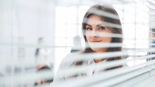 Joven mujer de negocios de pie cerca de ventana de oficina . — Foto de Stock