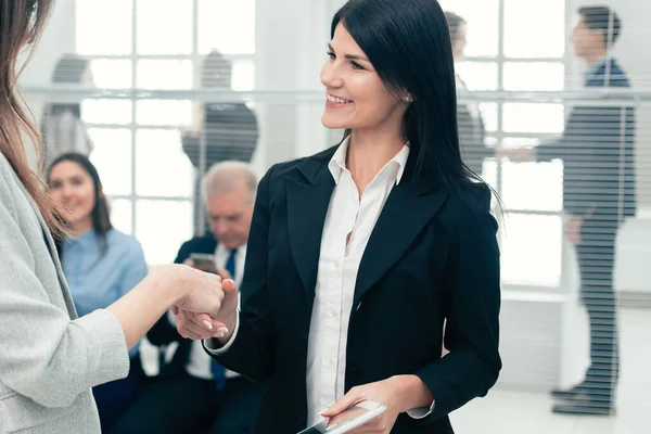 Dos mujeres de negocios estrechando la mano entre sí . — Foto de Stock