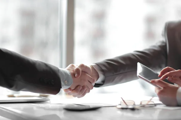 Закрывай. финансовые партнеры пожимают друг другу руки над столом — стоковое фото