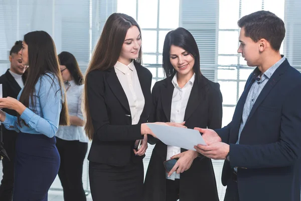 Group of young employees discuss a business document. — Stock Photo, Image