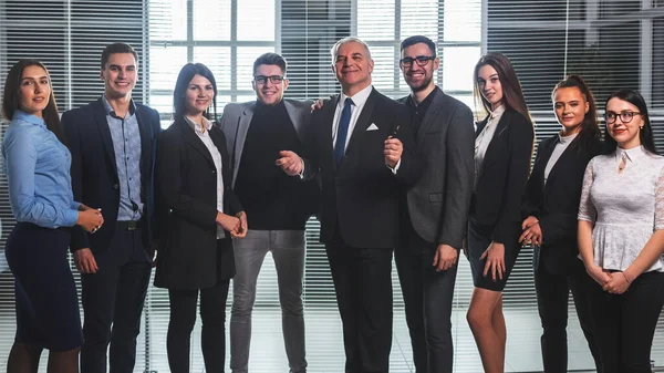 Grupp glada affärsmän står i kontorslobbyn — Stockfoto