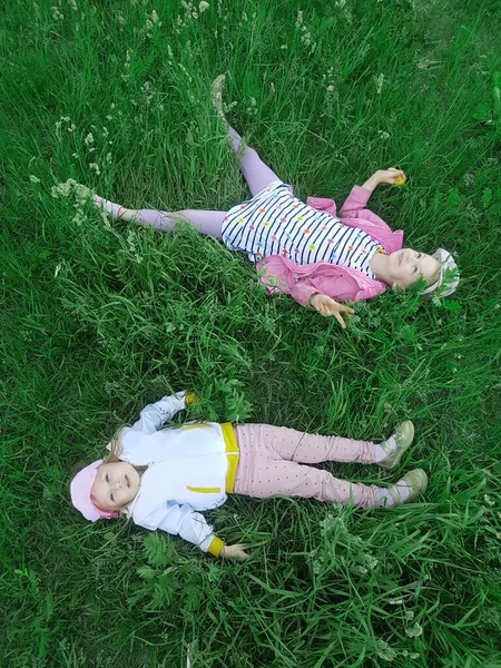 Anak-anak bahagia berbaring di rumput dan menikmati alam — Stok Foto