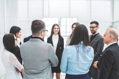 group of inspired young people stand and discuss a new project