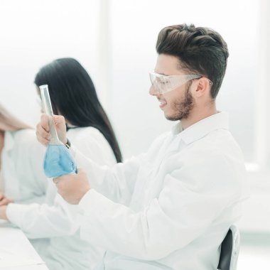 Bir grup bilim adamı laboratuardaki sıvıyı inceliyor.