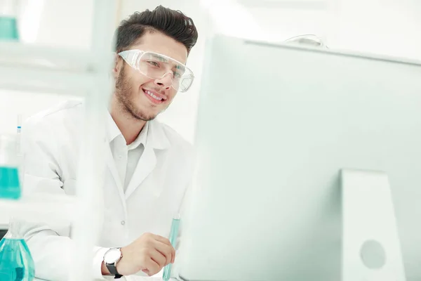 De cerca. joven científico mirando monitor de computadora . — Foto de Stock