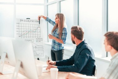 İş kadını ofisteki bir toplantıda iş adamlarına rapor verir.