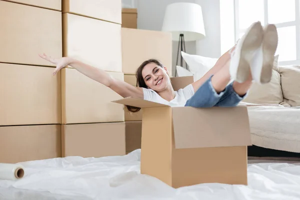 Счастливая молодая женщина распаковывает коробки в новой квартире — стоковое фото