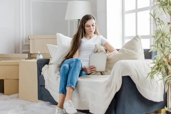 Mladá žena používá digitální tablet ve svém novém bytě — Stock fotografie