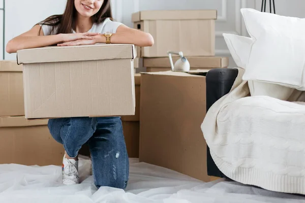 Feliz joven mujer desempacando cajas en nuevo apartamento — Foto de Stock