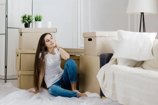 Šťastná mladá žena sedí na podlaze ve svém novém bytě — Stock fotografie