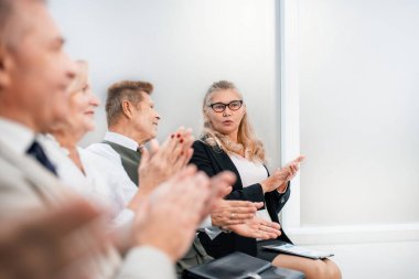 Kapat. Bir grup iş adamı iş semineri sırasında alkışlıyorlar..