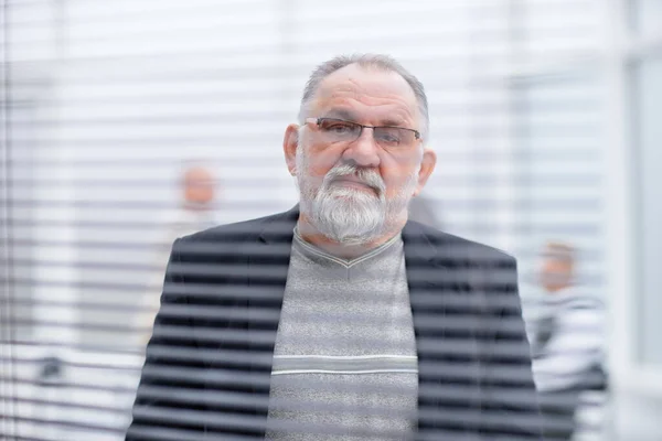 Anciano exitoso hombre de negocios mirando por la ventana de la oficina . —  Fotos de Stock