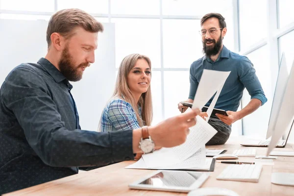 Geschäftsmann und lächelnde Mitarbeiter prüfen Finanzbericht. — Stockfoto