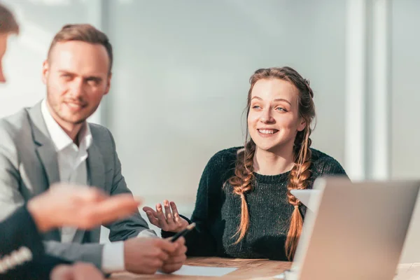 Uma jovem sorridente num encontro com um grupo de trabalho. — Fotografia de Stock