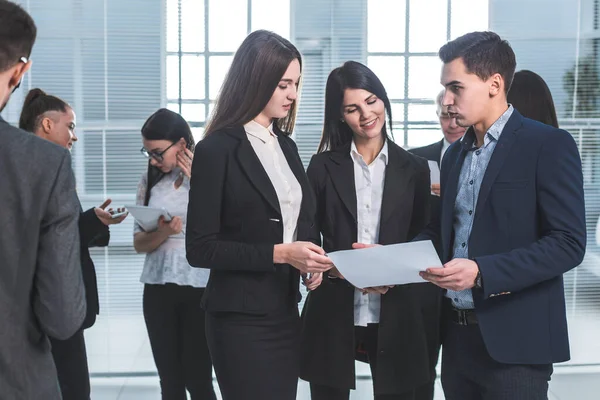 Grupo de jóvenes empleados discuten un documento de negocios . — Foto de Stock