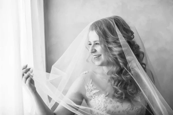 Close up. happy young woman bride looking through the window. — ストック写真