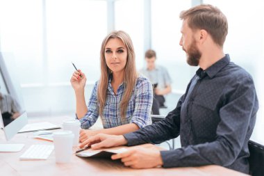 Ofis masasında oturup finansal verileri tartışan çalışanlar