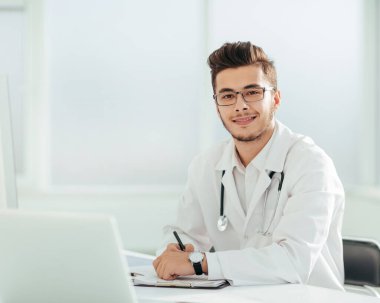 Doktor terapist ofisinde bir masada oturuyor.