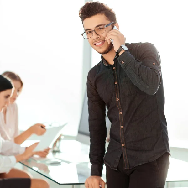 Jonge zakenman praten op zijn smartphone in het kantoor — Stockfoto