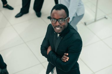 Gülümseyen genç işadamı kameraya bakıyor.