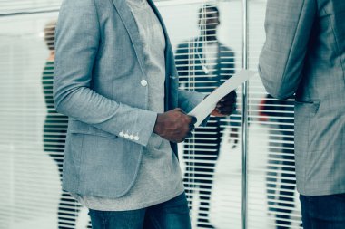 Kapat. Ofis çalışanları bir iş belgesini tartışıyor