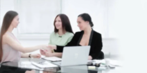 Handdruk van zakenpartners bij uw desk.woman en business. Achtergrond voor tekst met wazige mensen — Stockfoto