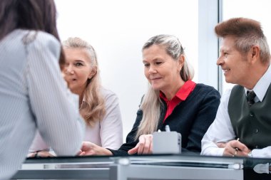 Çalışma grubu, ofisteki bir toplantıda mevcut görevleri tartışır..