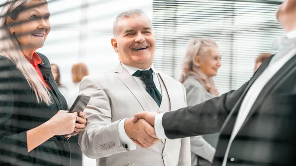 Κλείσε. χαμογελαστοί επιχειρηματίες χαιρετούν ο ένας τον άλλον με το χέρι — Φωτογραφία Αρχείου
