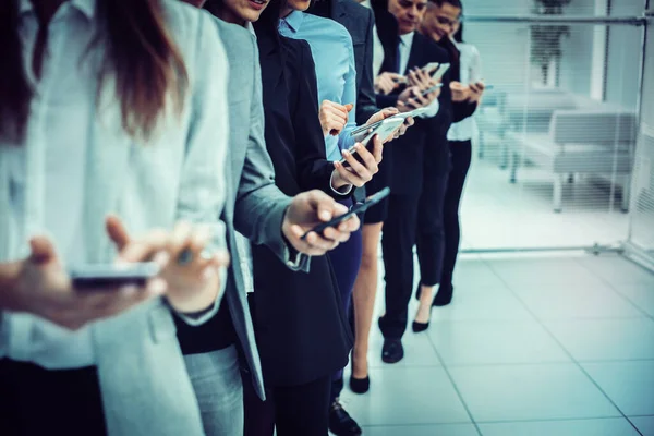 Grupo de jovens empresários olhando para suas telas de smartphones — Fotografia de Stock