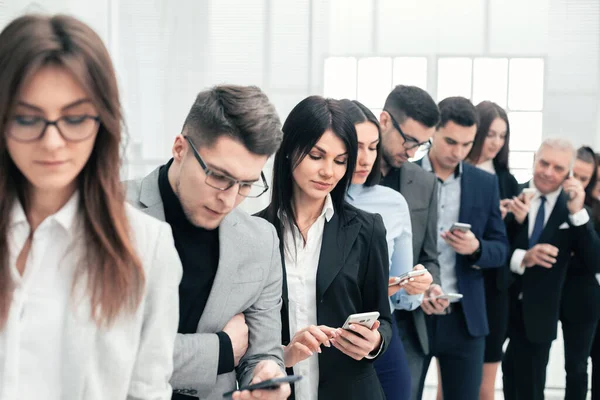 Grupo de jovens lendo mensagens em seus smartphones — Fotografia de Stock