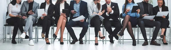 Groep medewerkers die hun apparaten gebruiken in de vergaderzaal. — Stockfoto