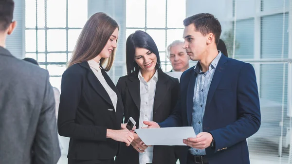 Groep jonge werknemers die tijdens een werkpauze in de kantoorlobby staan — Stockfoto