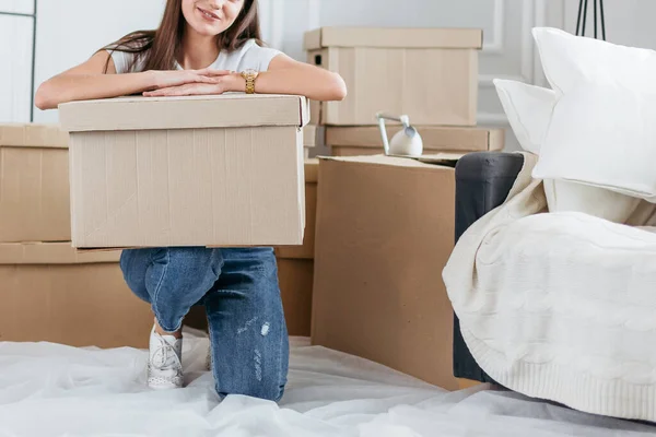 Šťastná mladá žena vybalování boxy v novém bytě — Stock fotografie