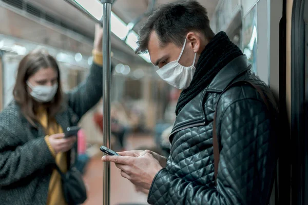 Passageiros em máscaras de proteção de pé no carro do metrô. — Fotografia de Stock