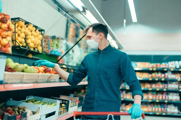 Customer in a protective mask filling a shopping cart. — Stock Photo, Image