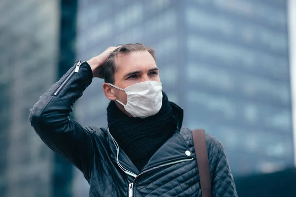 Junger Mann mit Schutzmaske steht auf der Straße — Stockfoto